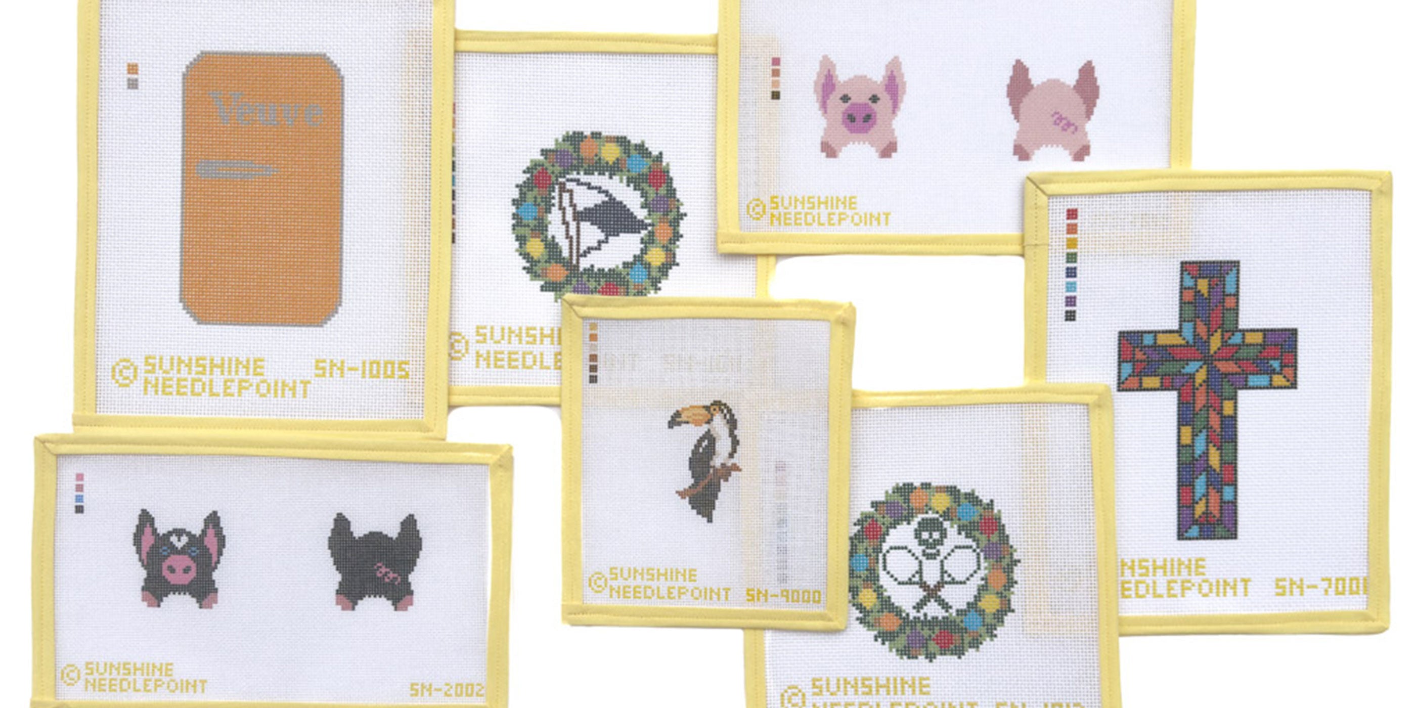 Collection of needlepoint canvases with various designs on a white background
