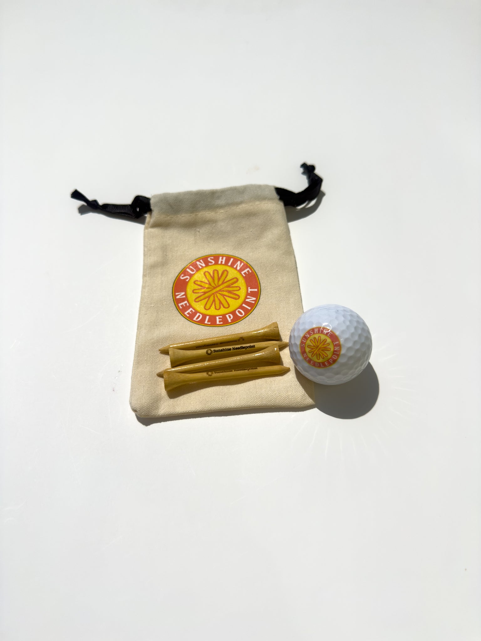 Sunshine Needlepoint branded golf ball and tees with bag
