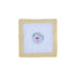 Cross-stitched design on fabric with a beige frame on a white background