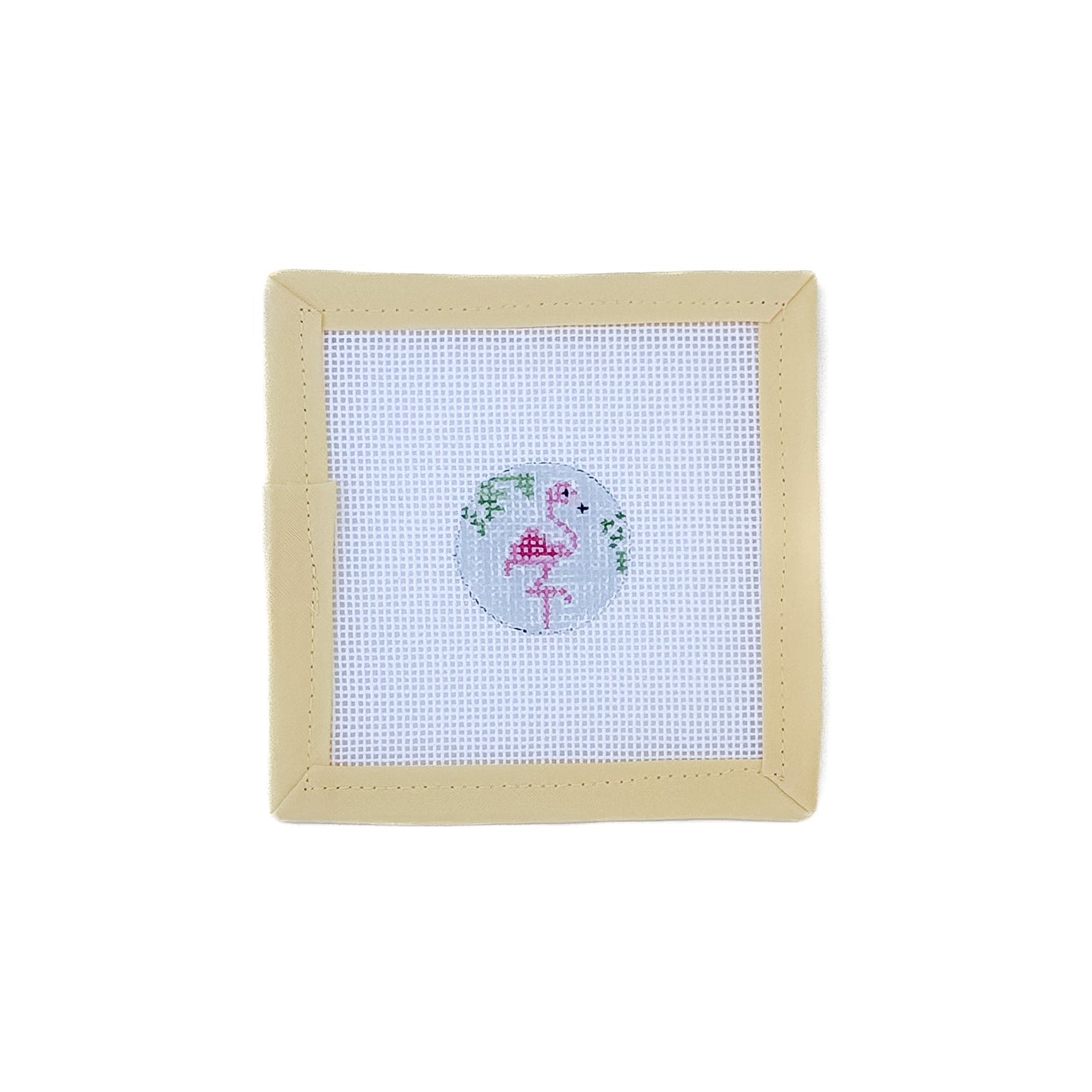 Cross-stitched design on fabric with a beige frame on a white background