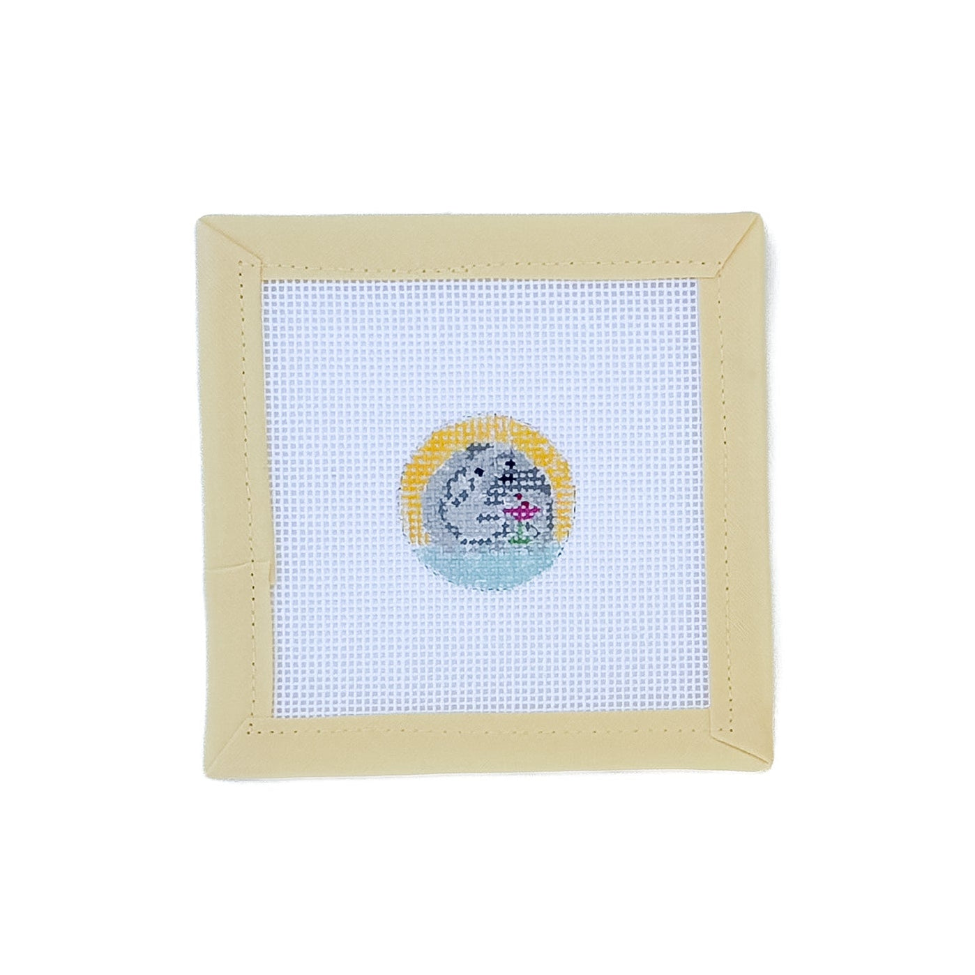 Cross-stitched design on fabric with a beige frame on a white background