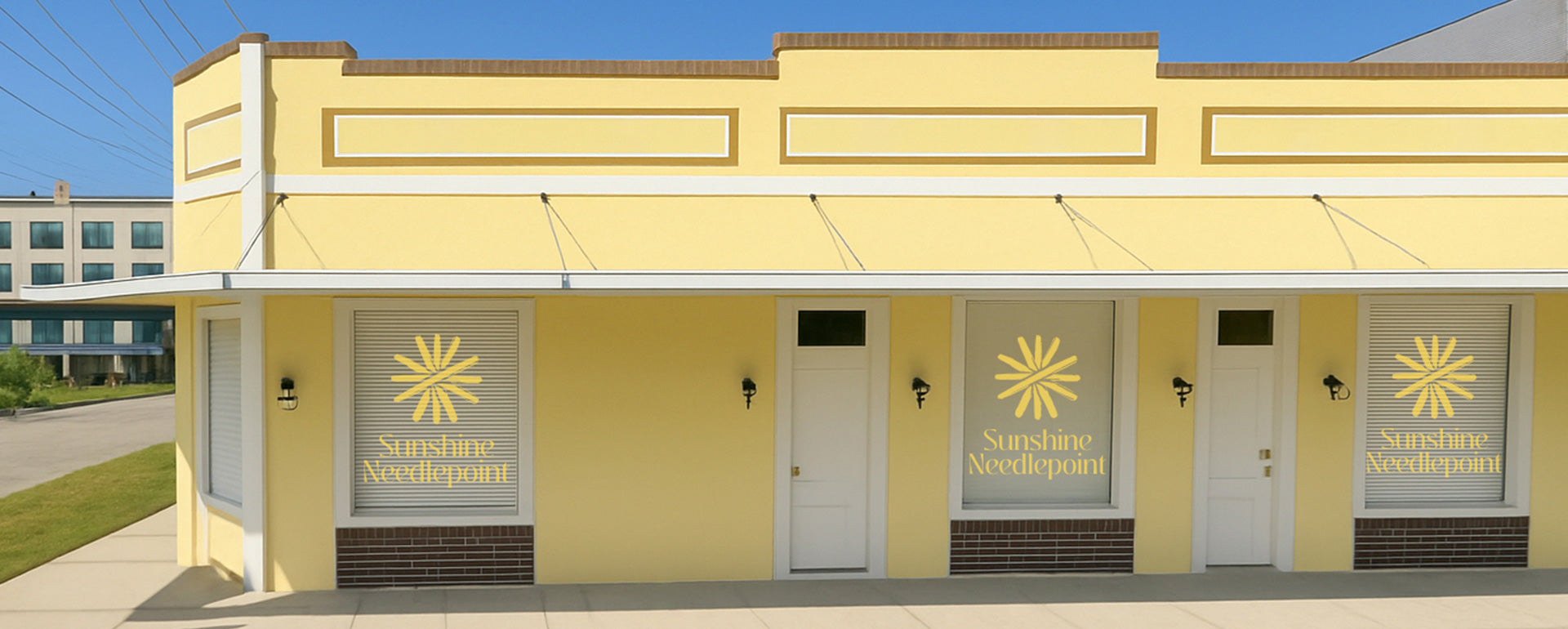 Yellow building with 'Sunshine Needlepoint' sign on a clear day